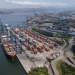 Complexo portuário brasileiro com navios, contêineres, rodovias e conexão ferroviária